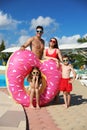 Family with inflatable ring near swimming pool.  Summer vacation Royalty Free Stock Photo