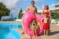 Family with inflatable ring near swimming pool.  Summer vacation Royalty Free Stock Photo
