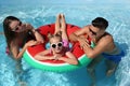 Family with inflatable ring in outdoor swimming pool on sunny summer day Royalty Free Stock Photo