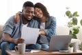 Family insurance. Black couple reading documentation at home, checking agreement together Royalty Free Stock Photo