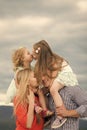 Family insurance. Girls kiss on mother father shoulders on cloudy sky Royalty Free Stock Photo