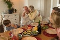 Family interacting with each other while having meal on dining table Royalty Free Stock Photo