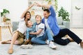 Family Joining Hands Making Symbolic Roof Sitting On Floor Indoors Royalty Free Stock Photo