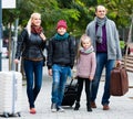 Family journey: spouses with children walking and luggage