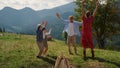 Family jumping raising hands up on green hill. Parents having fun with children. Royalty Free Stock Photo