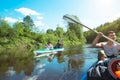 Family kayak trip. Father and daughter, and elderly couple senior and seniora rowing boat on the river, a water hike, a summer Royalty Free Stock Photo