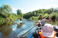 Family kayak trip. Father and daughter, and elderly couple senior and seniora rowing boat on the river, a water hike, a summer Royalty Free Stock Photo