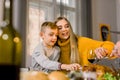 Family with kids eating Thanksgiving dinner. Roasted turkey on the table. Pretty mother and her little son sitting at