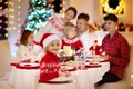 Family with kids having Christmas dinner at tree Royalty Free Stock Photo