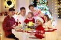 Family with kids having Christmas dinner at tree Royalty Free Stock Photo