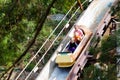 Family with kids on roller coaster in amusement theme park. Children riding high speed water slide attraction in entertainment fun