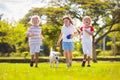 Kids play with dog. Children and puppy run in park Royalty Free Stock Photo