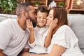 Family kissing and hugging each other sitting on sofa at home Royalty Free Stock Photo