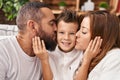 Family kissing and hugging each other sitting on sofa at home Royalty Free Stock Photo