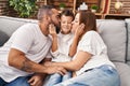 Family kissing and hugging each other sitting on sofa at home Royalty Free Stock Photo