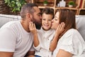 Family kissing and hugging each other sitting on sofa at home Royalty Free Stock Photo