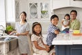 Family In Kitchen Doing Chores And Using Digital Devices Royalty Free Stock Photo