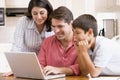 Family in kitchen with laptop smiling Royalty Free Stock Photo