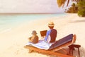 Family with laptop and touch pad on beach Royalty Free Stock Photo