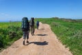 Family with large backpacks are on road sea