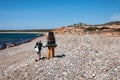 Family with large backpacks are on road sea