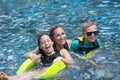 Family laughing and having fun together in an outdoor swimming pool on vacation Royalty Free Stock Photo