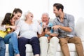 Family laughing while looking at smartphone photos Royalty Free Stock Photo