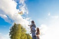Family launches kite against beautiful sky