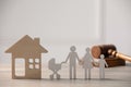 Family law. Figure of parents with children, house model and gavel on wooden table, space for text Royalty Free Stock Photo