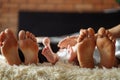 Family laying on bed, their feets on focus. Mother, father and newborn baby son Royalty Free Stock Photo