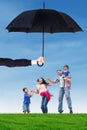 Family leap on the meadow under umbrella Royalty Free Stock Photo