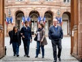 Family leaving polling place French city flags