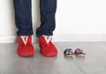 Family legs feet standing together, woman legs and small baby shoes on light background, conceptual photo of family and maternity, Royalty Free Stock Photo