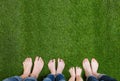 Family legs standing on green grass