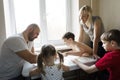 Family leisure: father, mother, sons and daughter play board games together