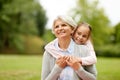 Granddaughter hugging grandmother at summer park Royalty Free Stock Photo