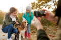 Family photographing by smartphone on autumn beach Royalty Free Stock Photo