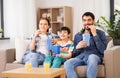 Happy family with popcorn watching tv at home