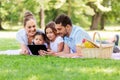 Family with tablet pc on picnic in summer park Royalty Free Stock Photo