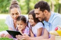 Family with tablet pc on picnic in summer park Royalty Free Stock Photo
