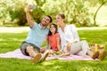 Family having picnic and taking selfie at park