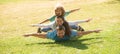 Family leisure time. Family lying on grass in park. Parents giving child piggybacks in park.