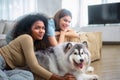 family LGBT diversity lesbian couple with dog in room. LGBT lifestyle