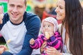 Family with little baby enjoying time at fun fair Royalty Free Stock Photo