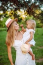 Family of little blonde girl and her middle age mother in the park in summer time. Childhood, single mother, age parents concept