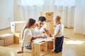 Family reading instruction and assemble furniture together at living room of new apartment pile of moving boxes on Royalty Free Stock Photo