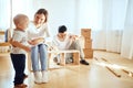 Family reading instruction and assemble furniture together at living room of new apartment pile of moving boxes on