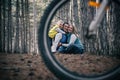 A family rides bicycles through the forest. A creative perspective through a bicycle wheel.