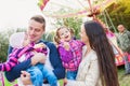 Family with little girls enjoying time at fun fair Royalty Free Stock Photo