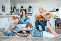 Family at living room together. Father playing chess with little son,mother learning online course on laptop,older son playing Royalty Free Stock Photo